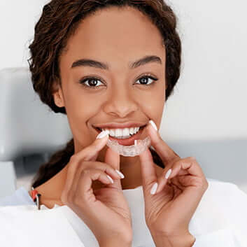 woman holding clear aligners