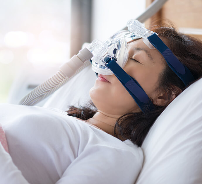 sleeping woman wearing a CPAP mask