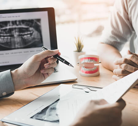 two people discussing paperwork and dental x-rays