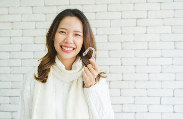 woman with invisalign to help with TMJ disorder