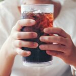 woman holding a soda, how diet affects dental health, nutrition and oral health