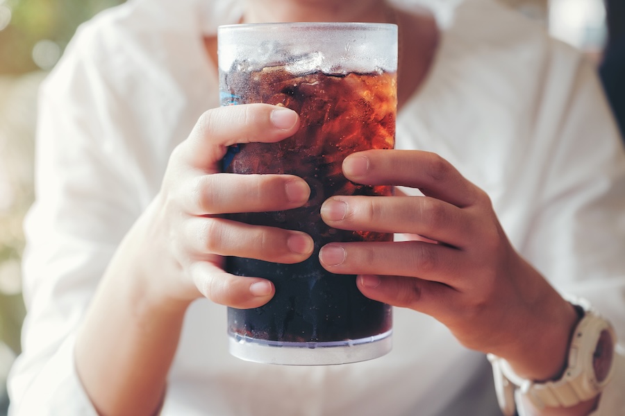 woman holding a soda, how diet affects dental health, nutrition and oral health